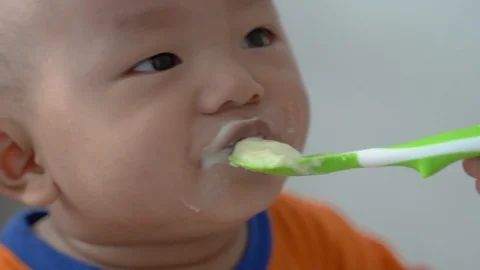Asian child eating solid food from mother Stock Footage 124070511