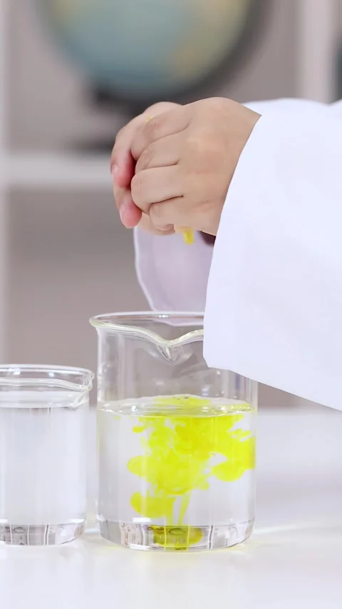 Asian Child in Lab Coat Squeezing Yellow Liquid into Beaker Stock-Footage 341732915