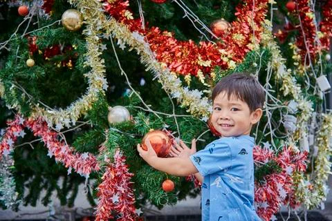 Asian Child Play With Christmas Tree And Present Boxes Stock Photos