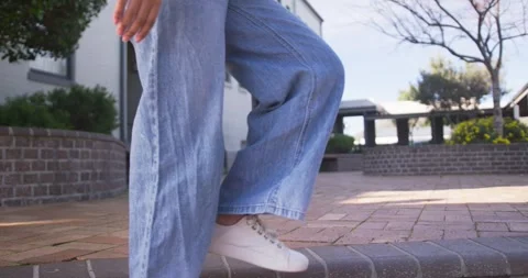 Asian child sitting ledge in courtyard, grasping laptop case, standing and Stock Footage 340656533