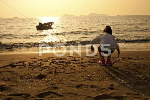 Asian children drawing on sand Stock Photos