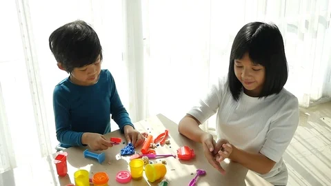 Asian children have a fun together with colorful modeling clay at home Stock Footage 91354853