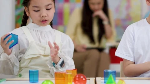 Asian Children Learning Geometry with Translucent Shapes in Classroom Setting Stock Footage 328208619