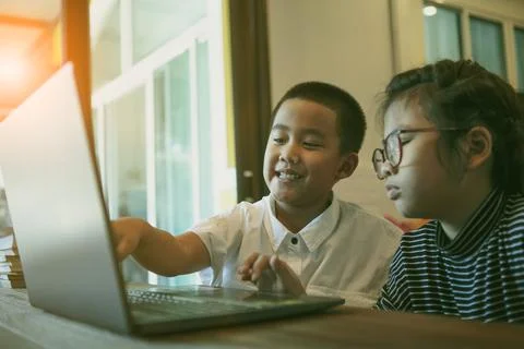 Asian children learning on line with computer laptop at home living room Stockfoto's