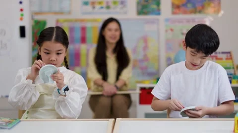 Asian Children Learning to Tell Time with Clock Toys in Classroom Stock Footage 330102194