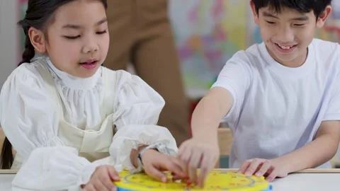 Asian Children Learning to Tell Time with Clock Toy in Classroom Stock Footage 330102284