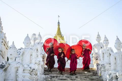 Asian Children With Parasols Balancing On Buddhist Shrine