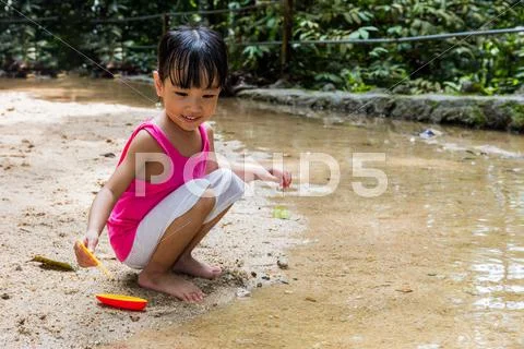Asian Chinese Little Girl Playing Toy Boat At Creek
