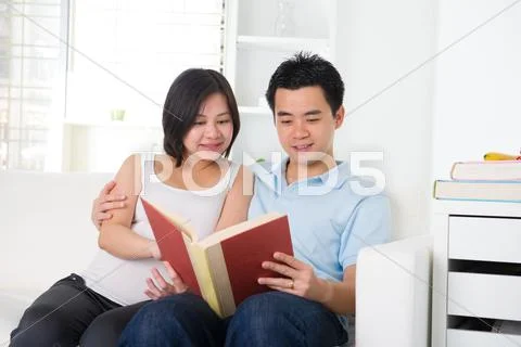 Asian chinese pregnant couple reading Stock-Fotos