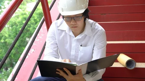 Asian civil engineer man checking document file at construction site Stock-Footage 90626918