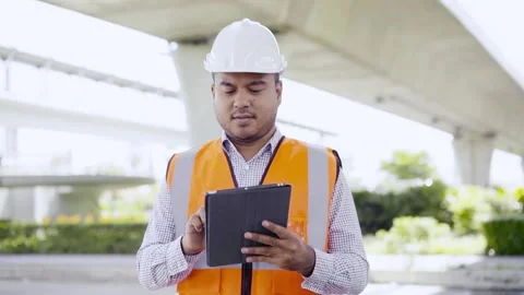 Asian civil engineer operate with tablet to control working at construction. Wor Stock Footage