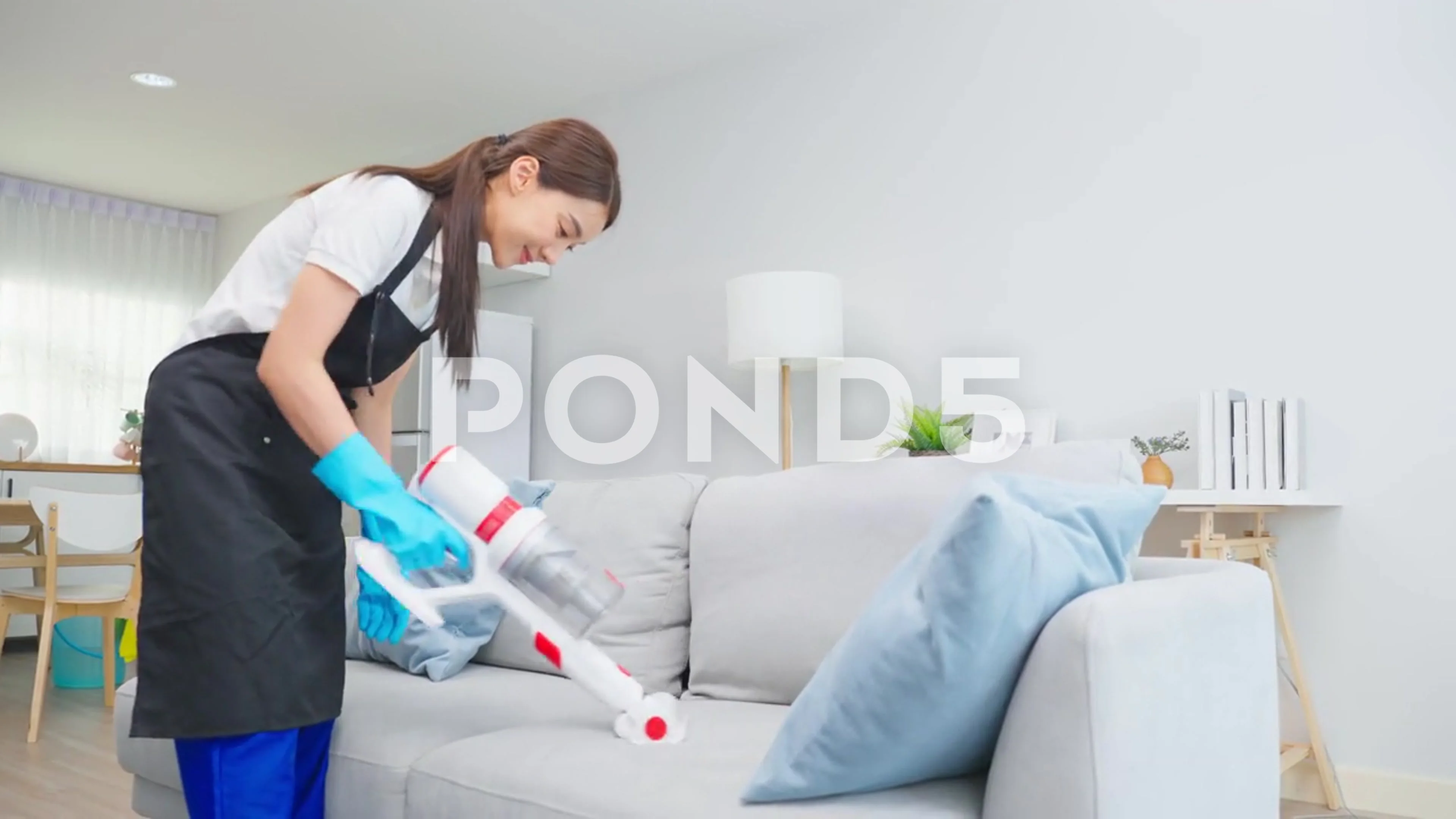 Asian cleaning service woman worker cleaning in living room at home.