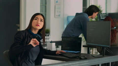 Asian coder turning head to work with holographic server code Stockbeeldmateriaal 224451671