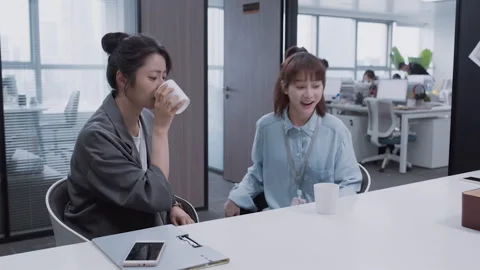 Asian colleagues chatting and using smartphone during office coffee break Video stock 333800392