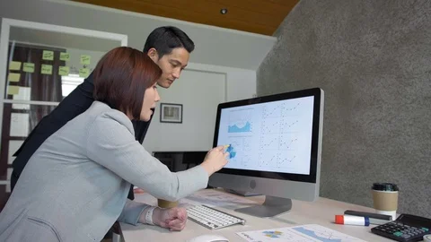 Asian Colleagues Discussing Chart Stock Footage 106237741