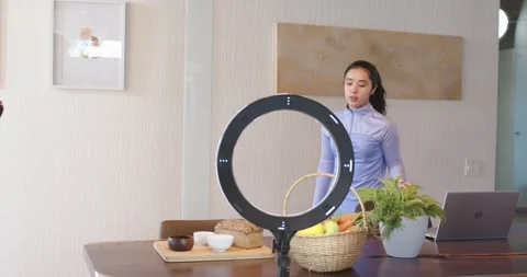 Asian colleagues walking up to dining table, arranging props, checking DSLR for 스톡 동영상 335906978