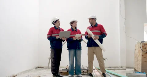 Asian construction team stands in unfinished interior, male contractor holds Stock Footage 345215587