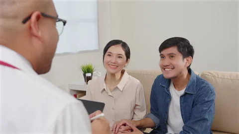 Asian couple discussing infertility problems with a handsome doctor. Stock Footage 245346431