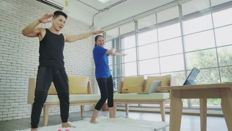 Asian couple doing exercise by follow video instruction. Stock Footage 147262240