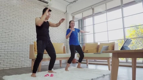 Asian couple doing exercise by follow video instruction. Stock Footage 147262256