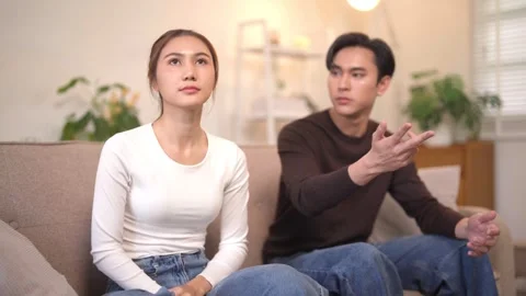 Asian couple faces relationship conflict on sofa young man woman argument d.. Stock Footage 333500891