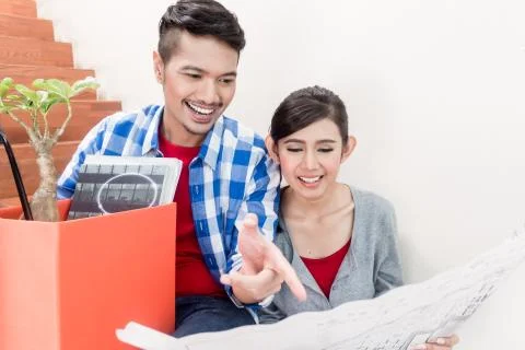 Asian couple with ground plot planning arrangement of new apartm Fotos de archivo