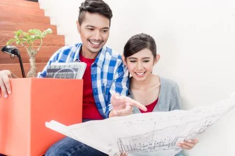 Asian couple with ground plot planning arrangement of new apartment Fotos de archivo