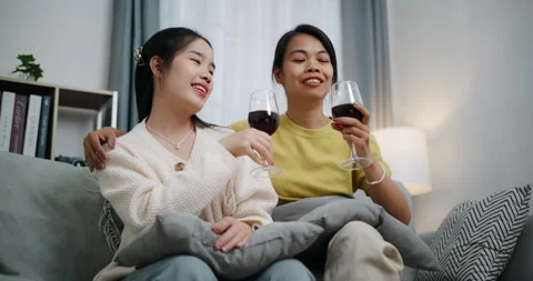 Asian couple happily chatting while relaxing on the sofa together. 스톡 동영상 316873484