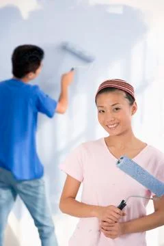 Asian couple painting interior of house Stock Photos