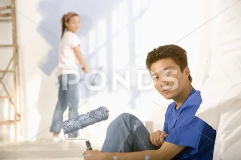 Asian couple painting interior of house Stock-Fotos