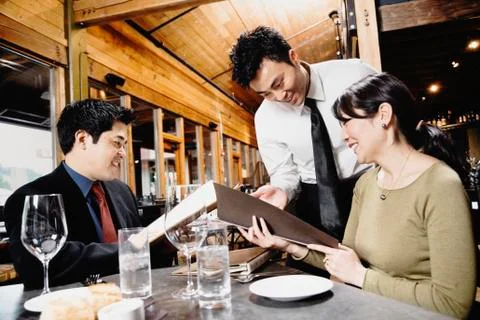 Asian couple reading menu at restaurant Stock Photos