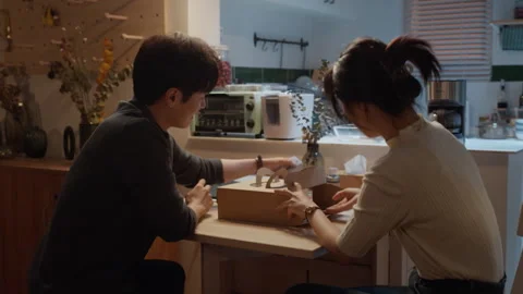 Asian couple sharing a pizza for dinner at home Stock Footage 333799153
