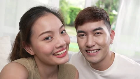 Asian couple using smart phone to connect with family for video call. Stock Footage 218574782