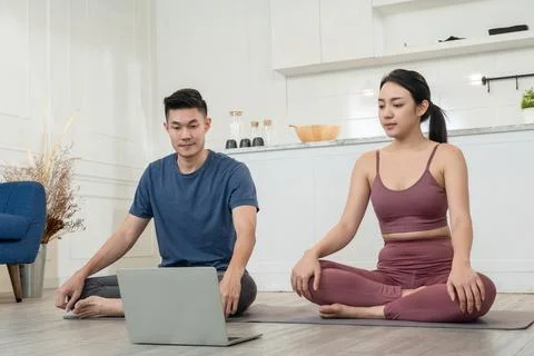 Asian couple watching exercise tutorial practice at home Stock Photos
