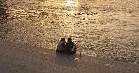 An Asian couple on the waterfront at sunset Stock Footage