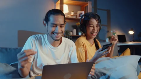 Asian couple work  laptop computer happy with wife  listen music in smartphone. Stock Footage 152992216