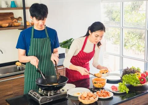 Asian couple young man and girl are cooking so enjoy in free time. Stock Photos