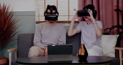 Asian couples wearing modern Virtual reality glasses sit and watch movies Stock Footage 164659864