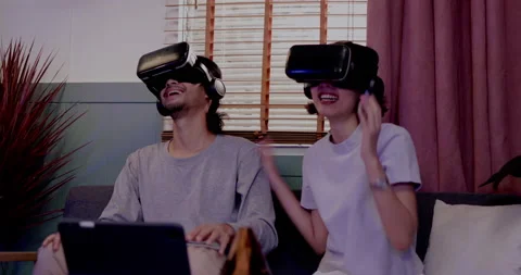 Asian couples wearing modern Virtual reality glasses sit and watch movies 動画素材 164660157