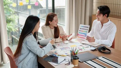 Asian creative design team brainstorming mobile app interface in office Stock Photos