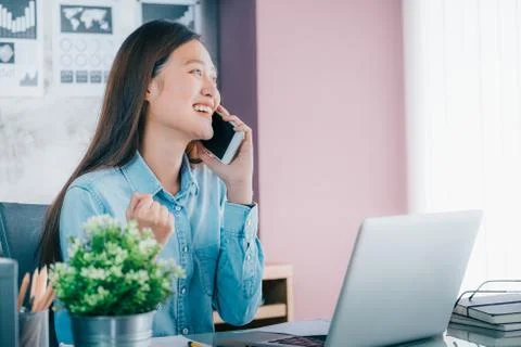 Asian creative designer looking forward to window and hand up with smiling fa Stock Photos