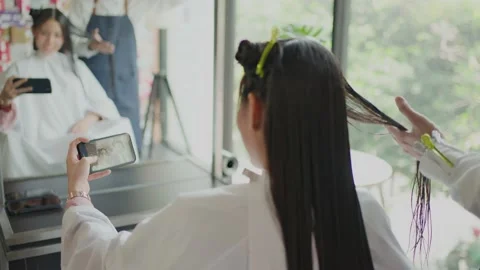 Asian customer live streaming while a hairdresser giving treatment service Stock Footage 167843975