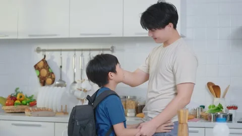 Asian cute boy back from school ran into his father was cooking in kitchen Stock Footage 236352610