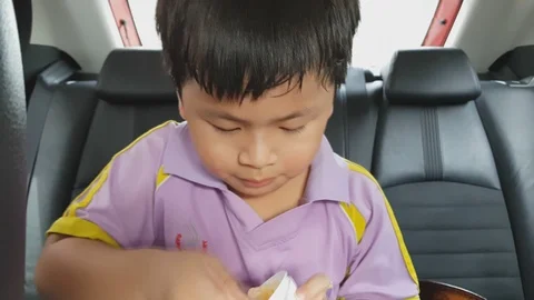 Asian cute a boy eating corn flake in the car, Stockbeeldmateriaal 95680827
