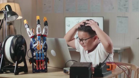 Asian Cute Boy Having A Headache While Working About A Cyborg Hand On A Laptop Stock Footage 212016608