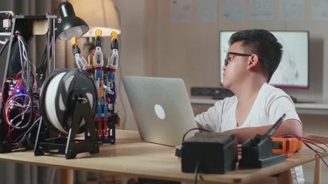 Asian Cute Boy Working About A Cyborg Hand On A Laptop At Home Video stock 212016216