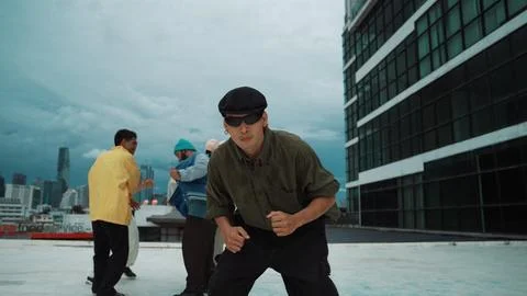 Asian dancer practice B boy dance while friends dancing at roof top. Endeavor. Stock Photos