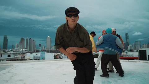 Asian dancer practice B boy dance while friends dancing at roof top. Endeavor. Stock Photos