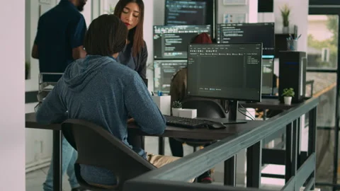 Asian database developers analyzing compiling code on multiple screens Stock Footage 217409202