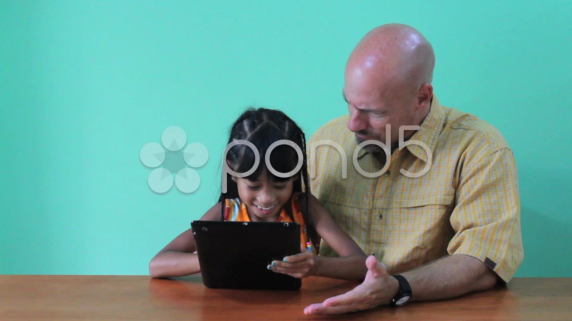 Asian Daughter Showing Dad Tricks On Digital Tablet